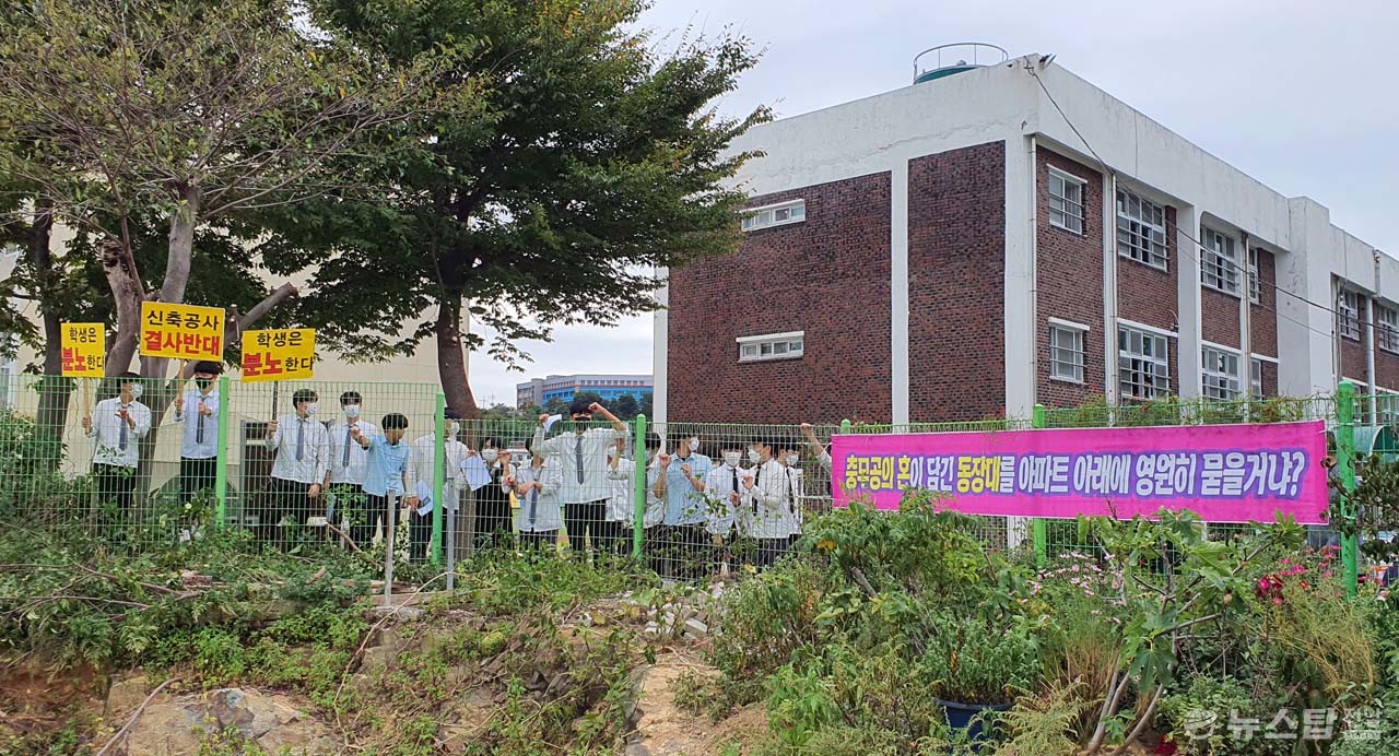 학교 담장 안에서 아파트 신축 반대 피켓을 들고 있는 학생들. (사진=마재일 기자)