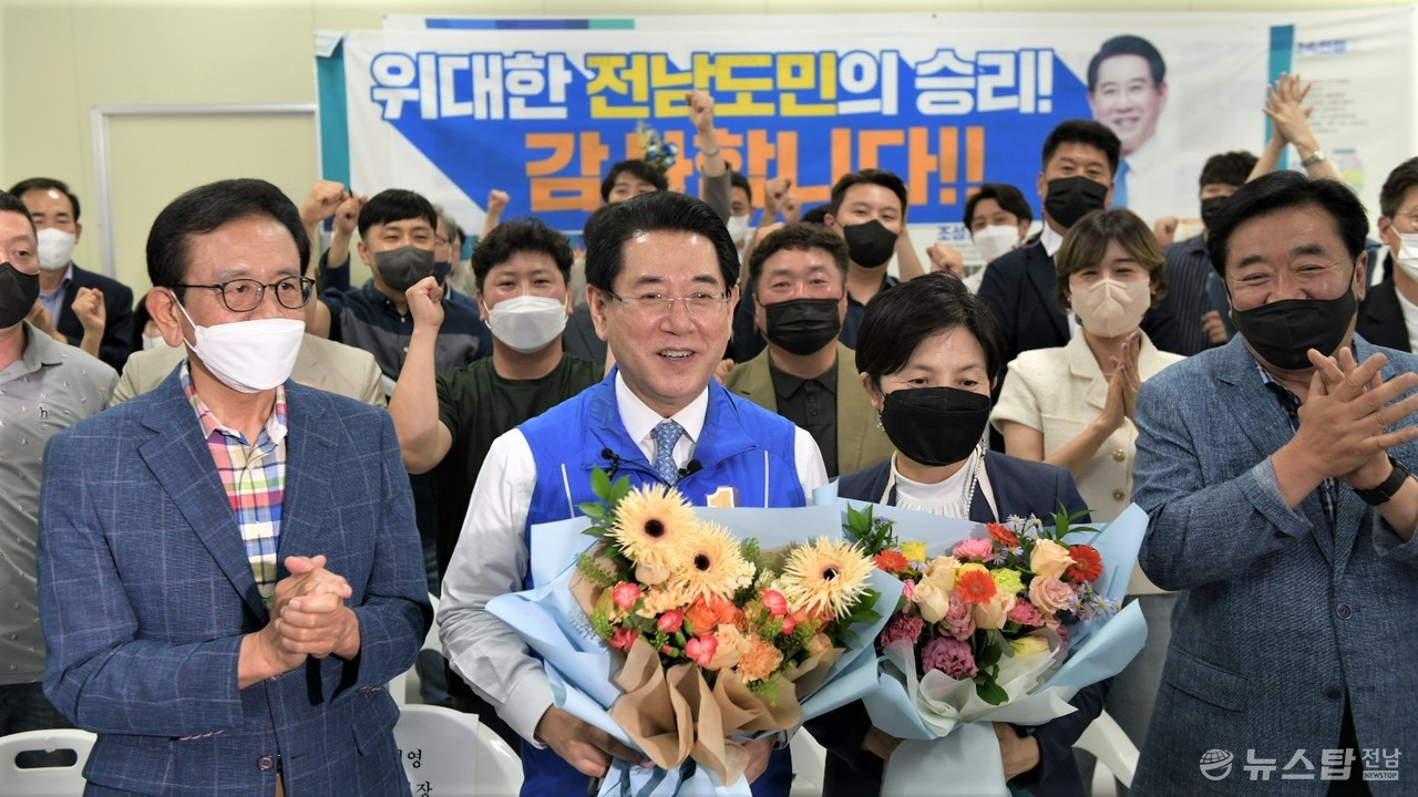 김영록 후보가 당선이 확실시되자 지지자들로부터 꽃다발을 받고 부인과 함께 기뻐하고 있다.