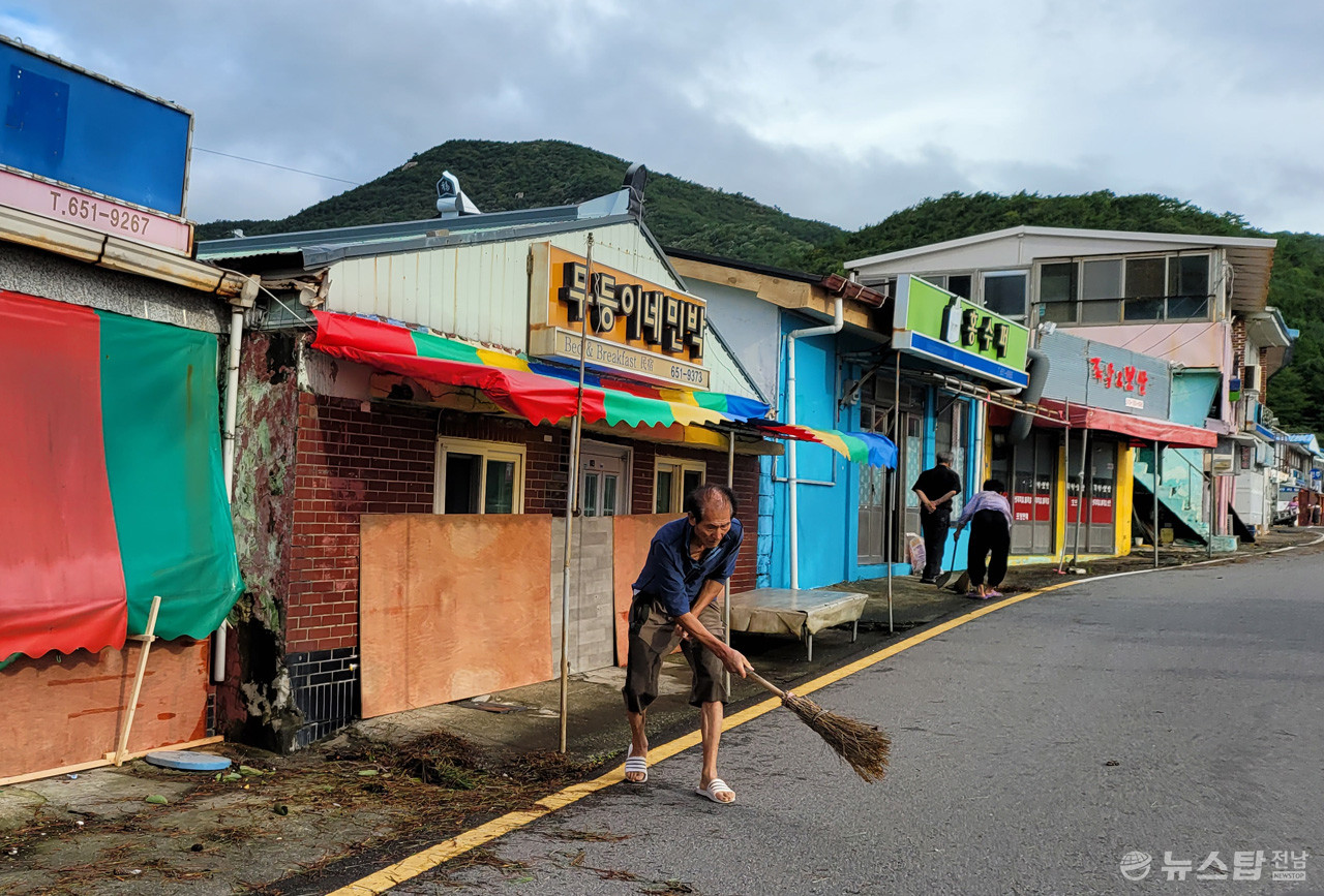 6일 오전 만성리 해수욕장 상인들이 가게 앞 쓰레기를 치우고 있다. (사진=마재일 기자)